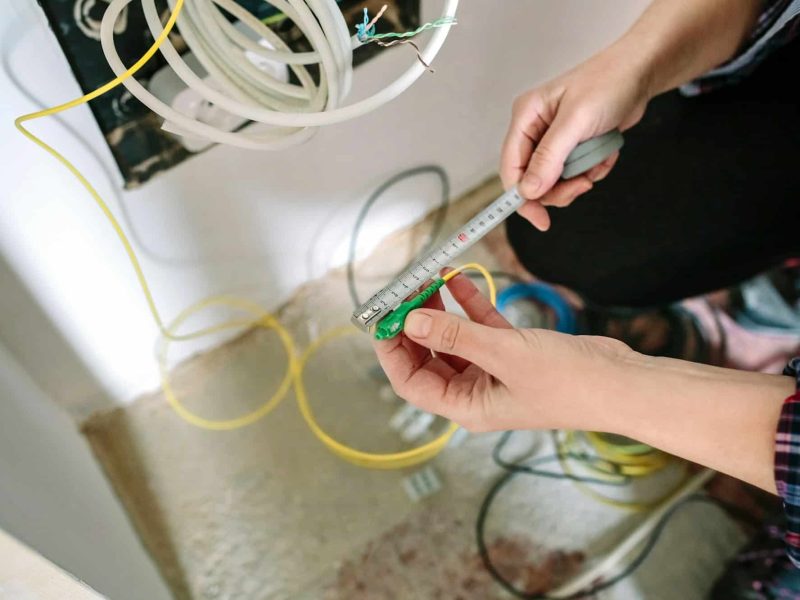 Telecommunications installer measuring fiber optic cable